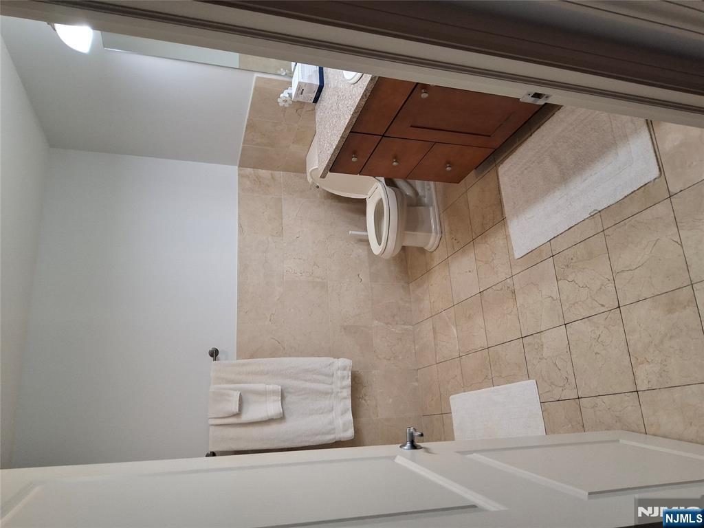 6407 City Place, Unit 6407 Edgewater, NJ 07020 - Photo 7 of 9 a bathroom with a sink a toilet and mirror