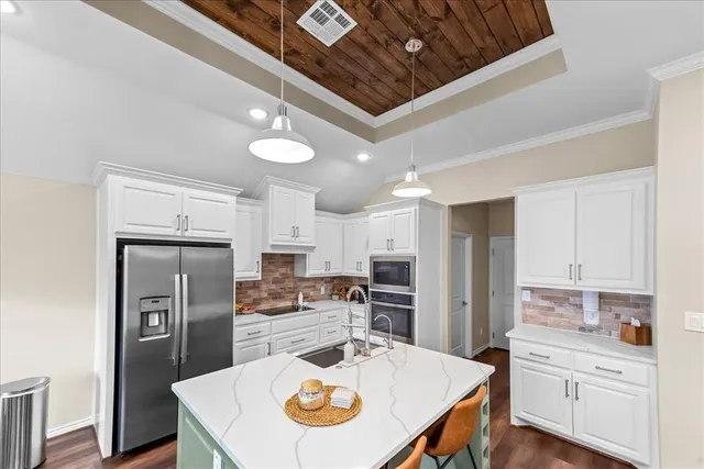 a kitchen with white cabinets and stainless steel appliances