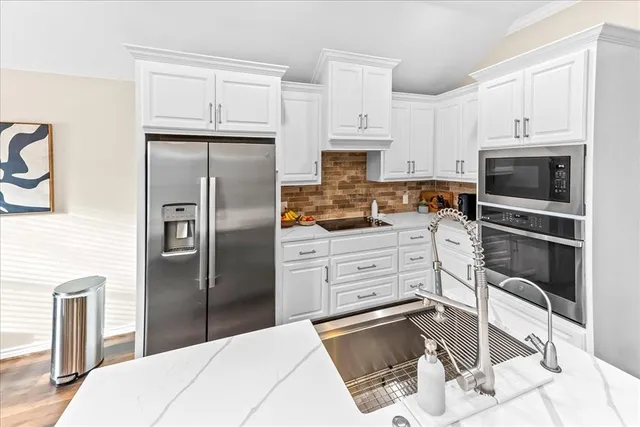 a large kitchen with a table chairs refrigerator and a window