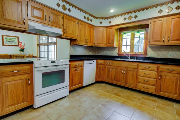 a kitchen with granite countertop a stove sink and cabinets