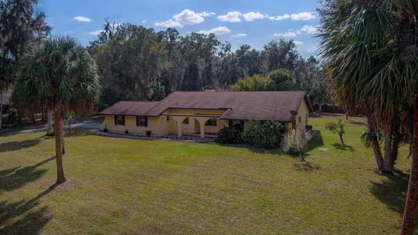 a view of a house with swimming pool next to a yard