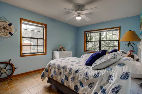 a bedroom with a bed a chandelier and a window