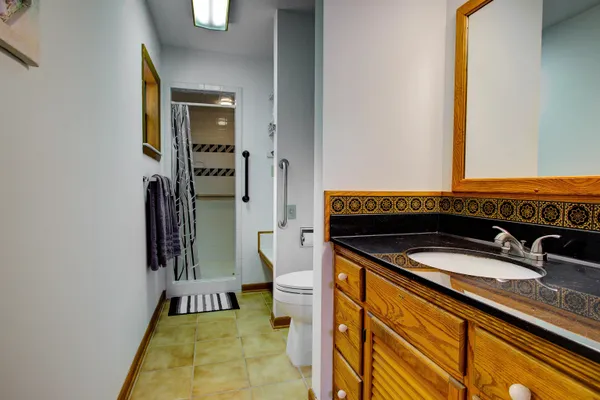 a bathroom with a granite countertop sink and a mirror