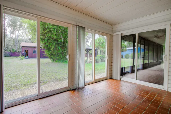 a view of a porch with wooden floor and floor to ceiling window