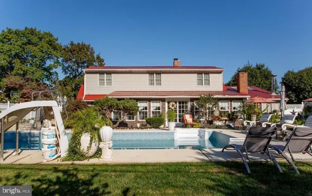 a front view of a house with garden and sitting area