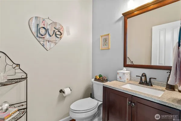 a bathroom with a granite countertop sink mirror and toilet