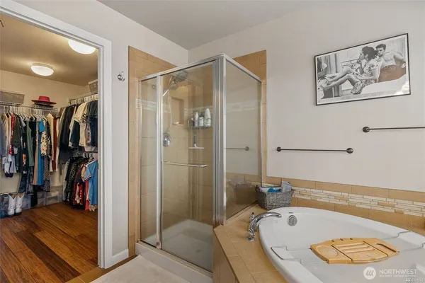a bathroom with a tub a window and a shower