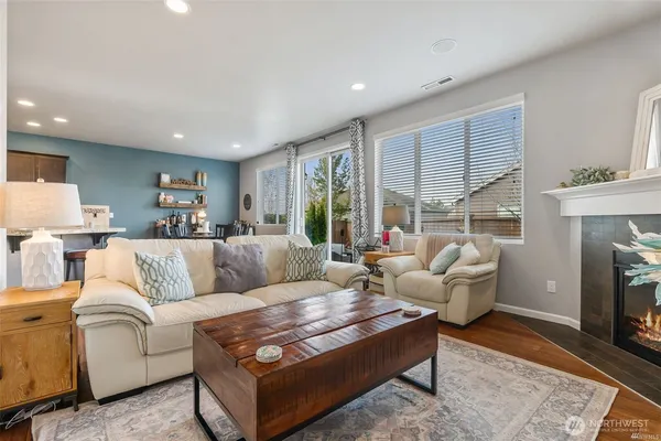 a living room with furniture fireplace and a large window