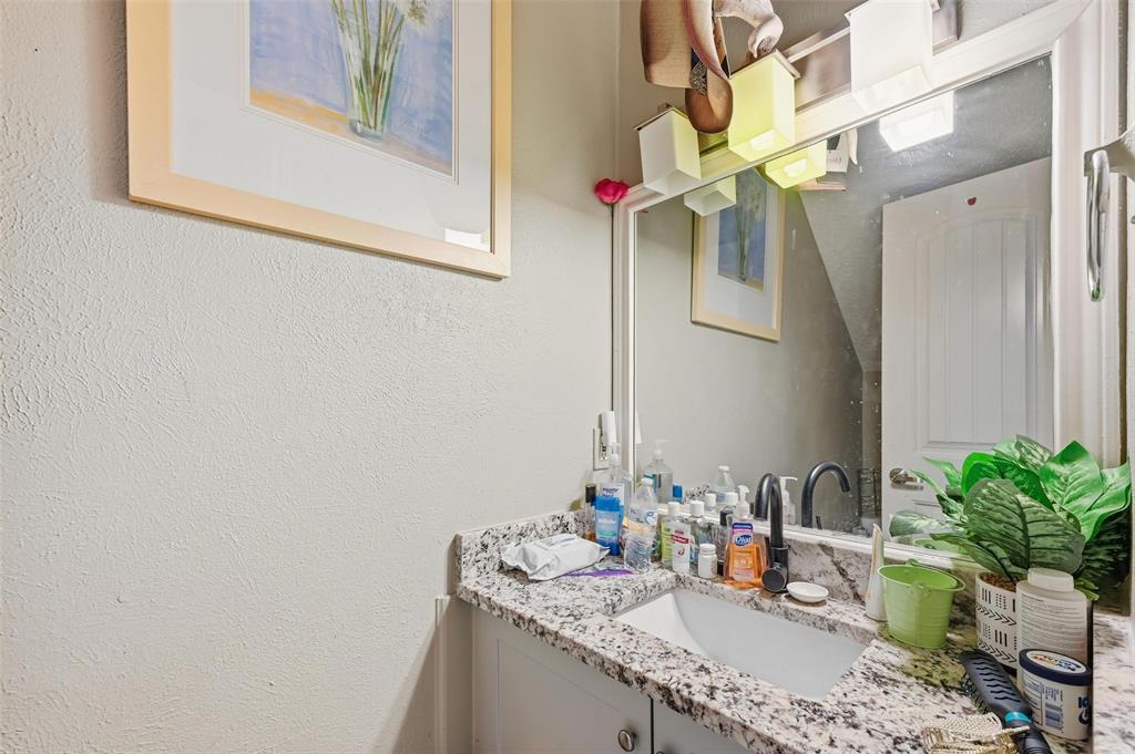 8001 Rothington Road, Unit 3137 Dallas, TX 75227 - Photo 35 of 38 a bathroom with a granite countertop sink a mirror and vanity