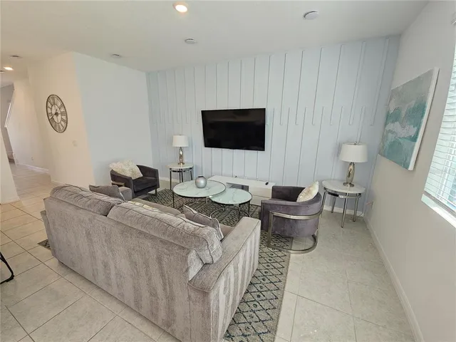 a kitchen with a dining table chairs refrigerator and microwave