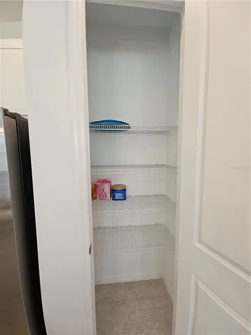 a bedroom with a bed and a refrigerator