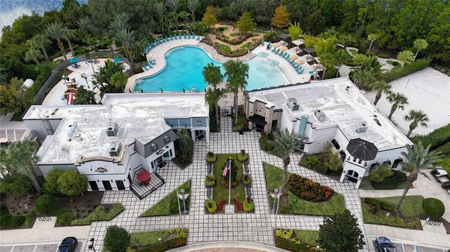 a view of swimming pool with a lounge chair and palm trees