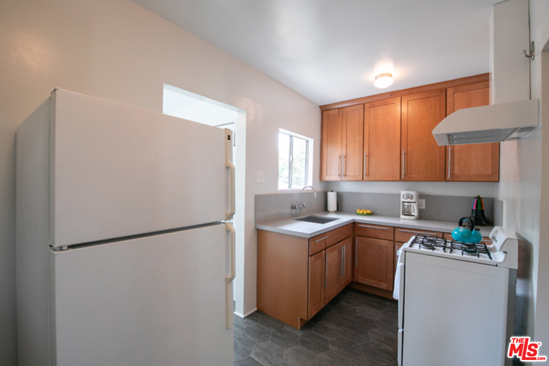 5122 Raphael Street Los Angeles, CA 90042 - Photo 15 of 37 a kitchen with a sink a refrigerator and cabinets
