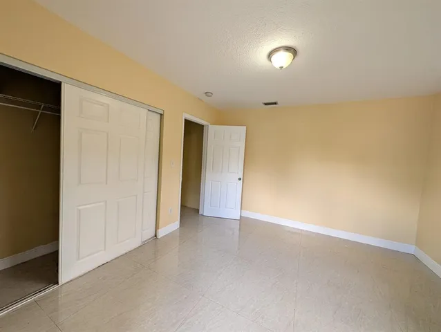 a view of empty room with windows and closet