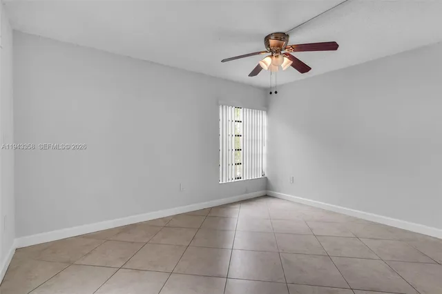 a view of an empty room with a ceiling fan
