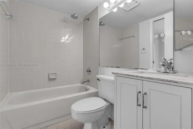 a bathroom with a granite countertop sink a toilet and shower