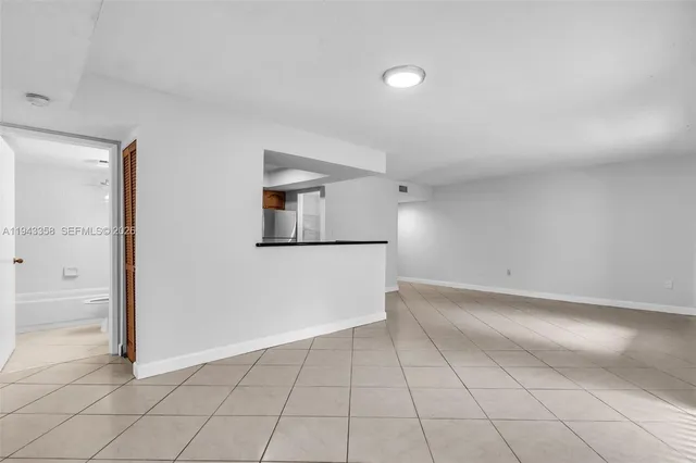 an empty room with windows and chandelier fan