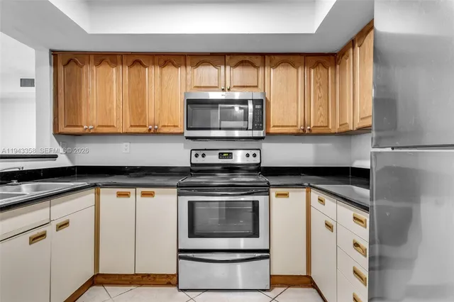 a kitchen with white cabinets and appliances