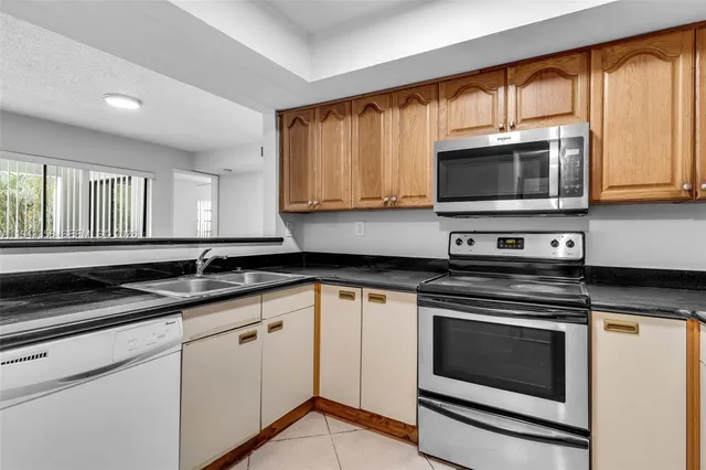 a kitchen with granite countertop cabinets stainless steel appliances and a sink