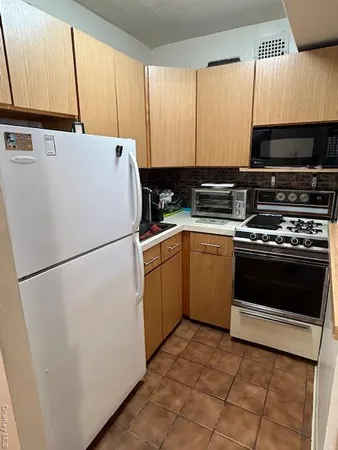a white refrigerator freezer and a stove in a kitchen