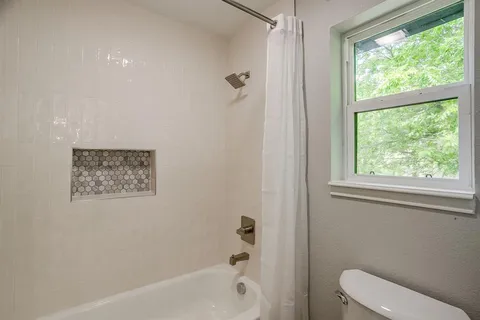 a bathroom with a toilet and a shower