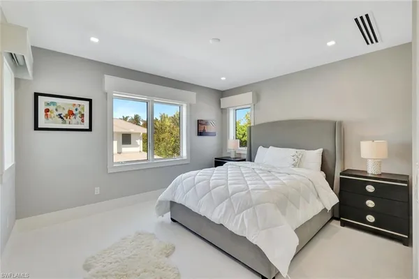 a living room with furniture and painting on the wall with wooden floor