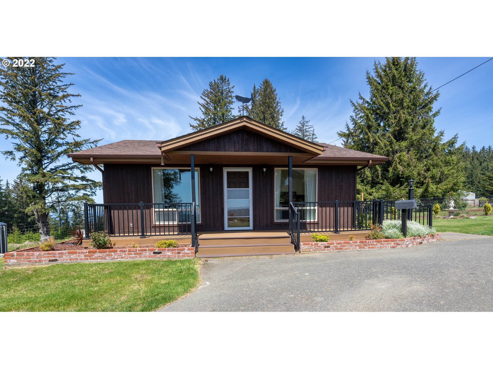 95525 West Huckleberry Ridge Road Brookings, OR 97415 - Photo 22 of 32 a backyard of a house with table and chairs