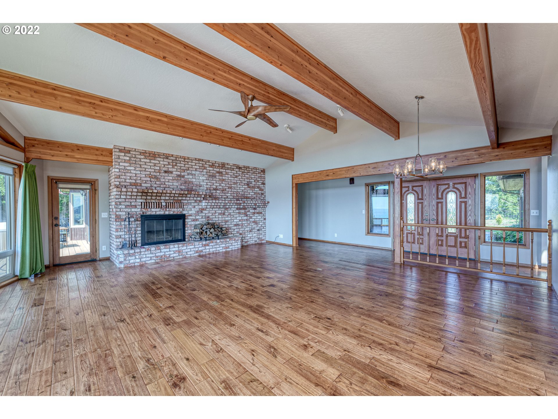 95525 West Huckleberry Ridge Road Brookings, OR 97415 - Photo 6 of 32 a view of an empty room with wooden floor and a fireplace