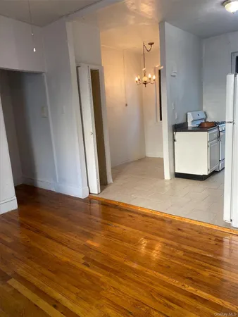 an empty room with wooden floor and a bathroom