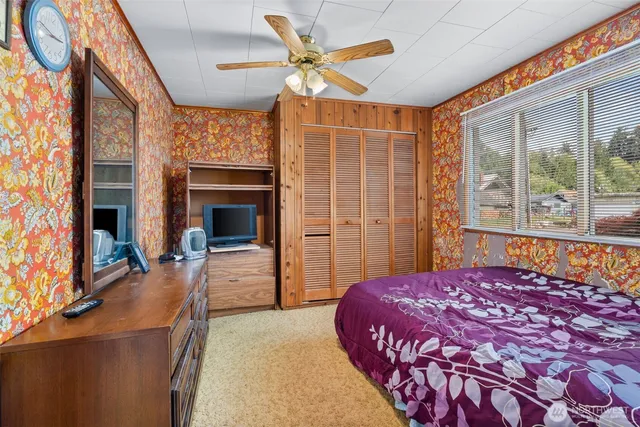 a bedroom with a bed and a large window with outer view