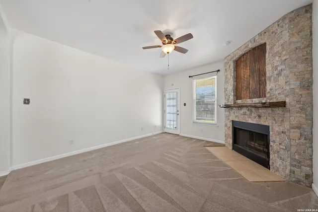 a view of empty room with fireplace and fan