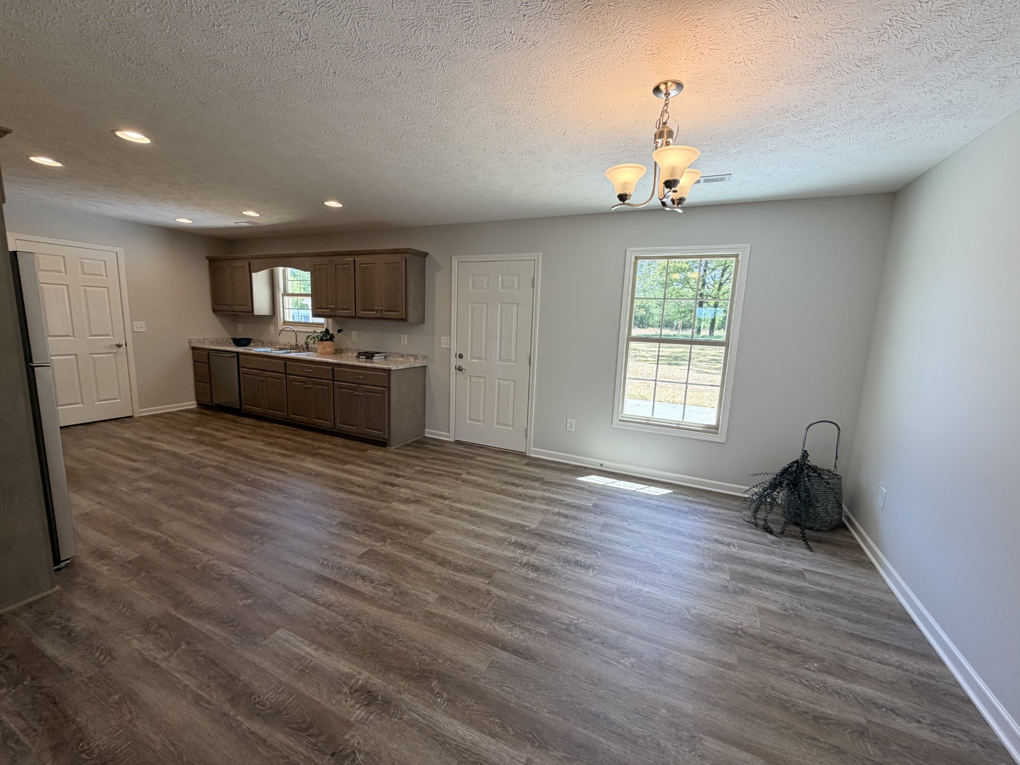 74 6 Mile Board Road Winchester, TN 37398 - Photo 58 of 99 an empty room with wooden floor chandelier and windows