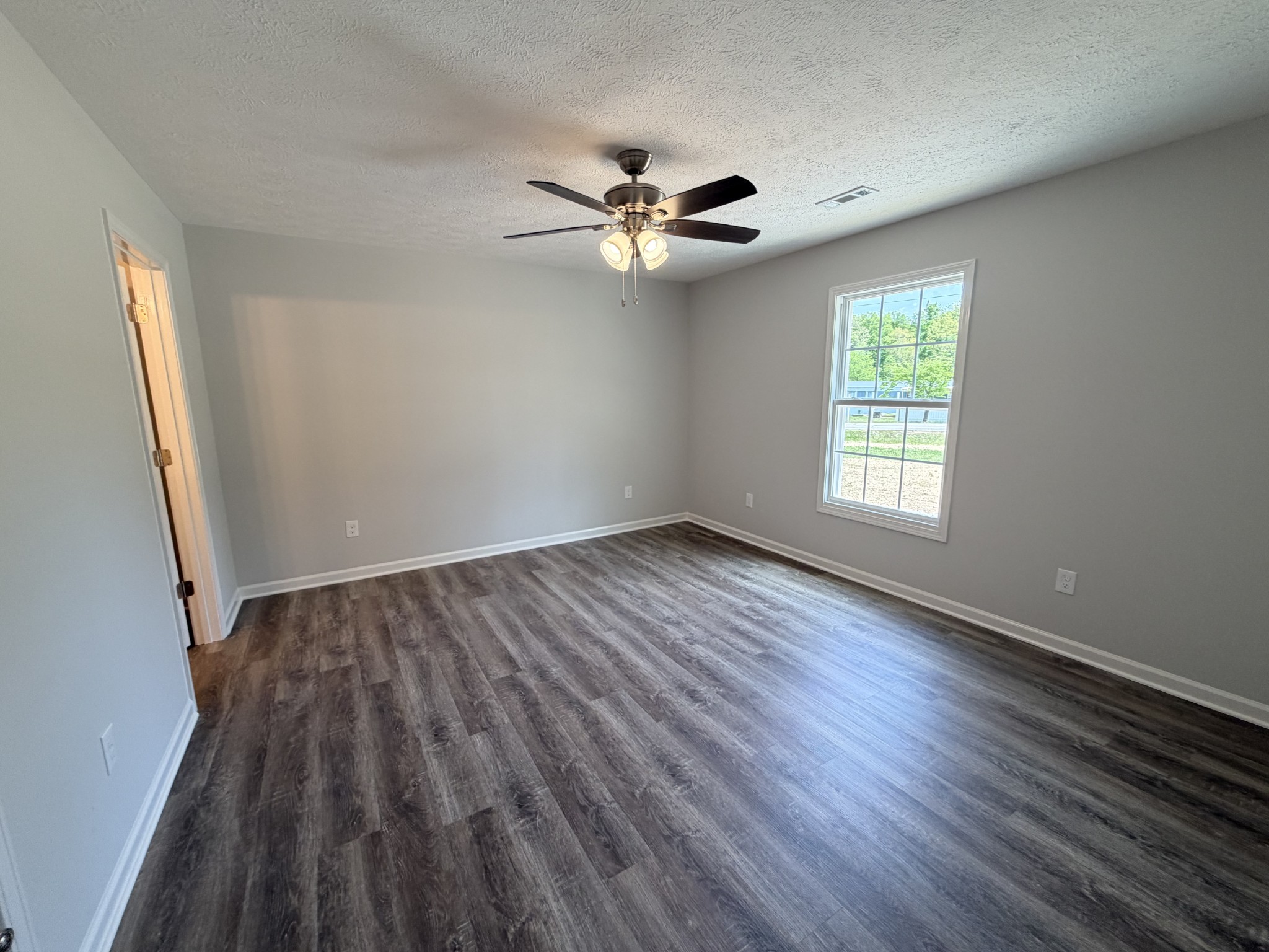 74 6 Mile Board Road Winchester, TN 37398 - Photo 74 of 99 an empty room with wooden floor fan and windows