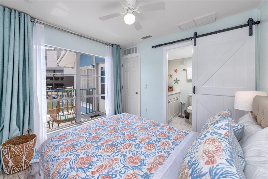 159 Medallion Boulevard, Unit H Madeira Beach, FL 33708 - Photo 22 of 57 a bedroom with a large bed and a large window