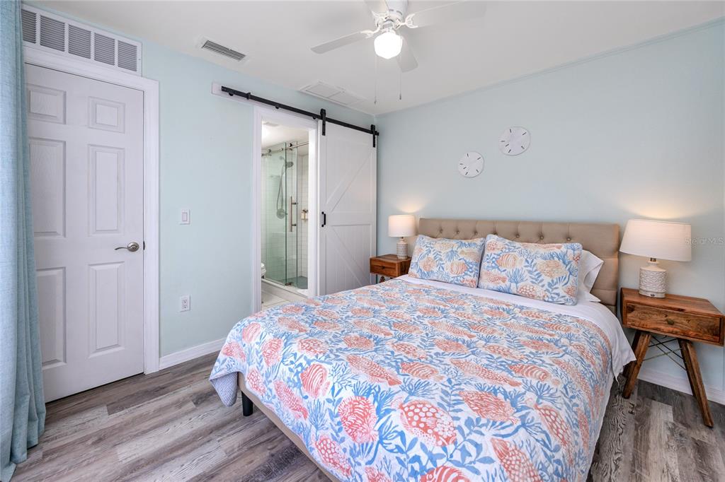 159 Medallion Boulevard, Unit H Madeira Beach, FL 33708 - Photo 24 of 57 a bedroom with a bed and a chandelier