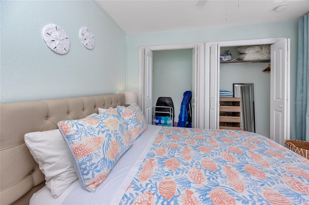159 Medallion Boulevard, Unit H Madeira Beach, FL 33708 - Photo 25 of 57 a bedroom with a bed and a chandelier