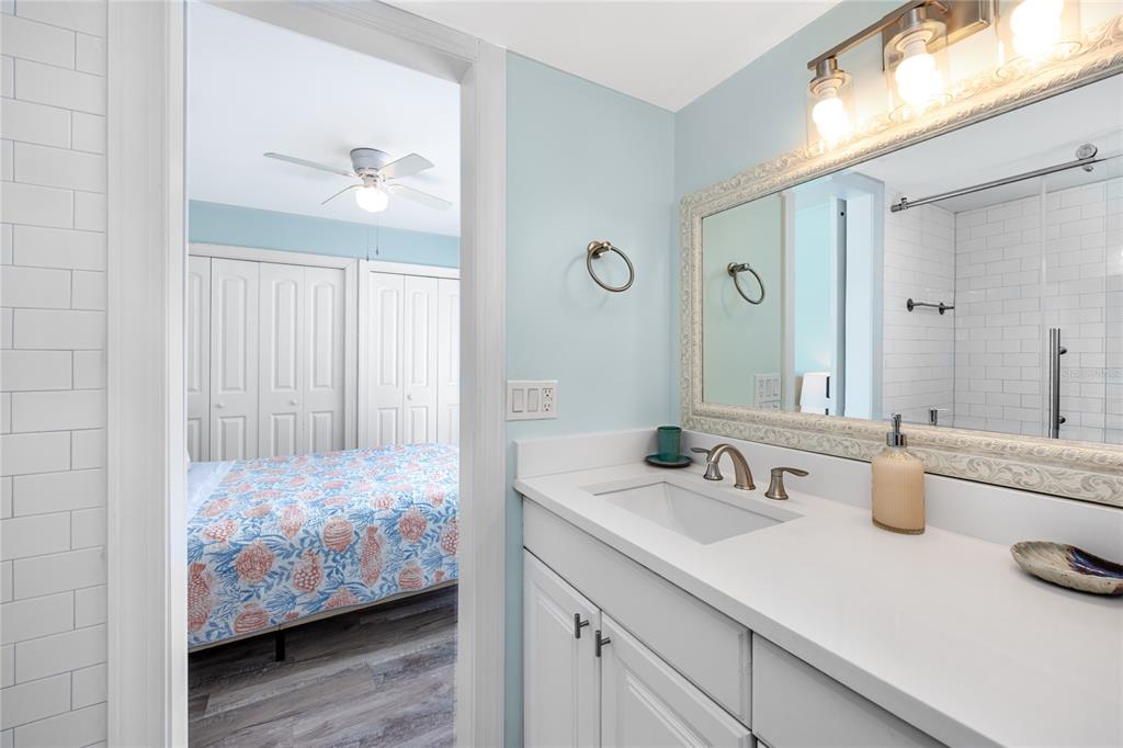 159 Medallion Boulevard, Unit H Madeira Beach, FL 33708 - Photo 27 of 57 a en suite bathroom with a granite countertop sink and a mirror