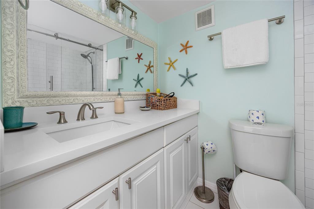 159 Medallion Boulevard, Unit H Madeira Beach, FL 33708 - Photo 28 of 57 a bathroom with a granite countertop toilet sink and mirror