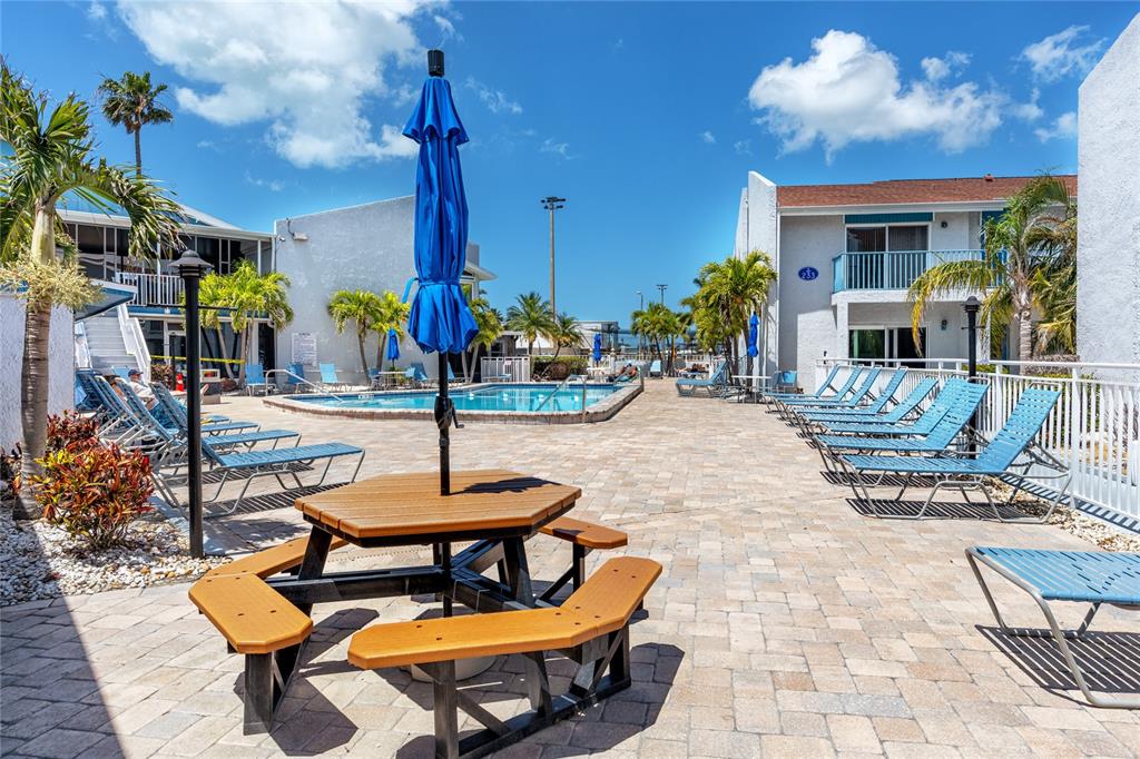 159 Medallion Boulevard, Unit H Madeira Beach, FL 33708 - Photo 39 of 57 a view of a patio with a table and chairs