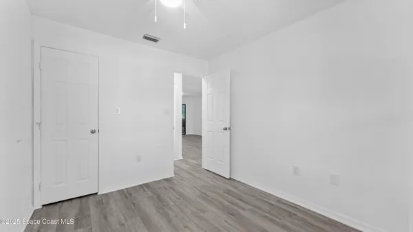 a view of an empty room with wooden floor