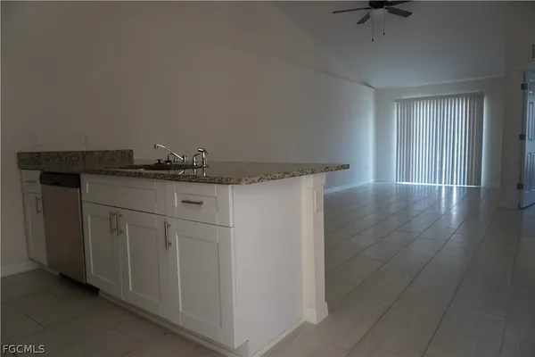 a kitchen with granite countertop a sink and cabinets