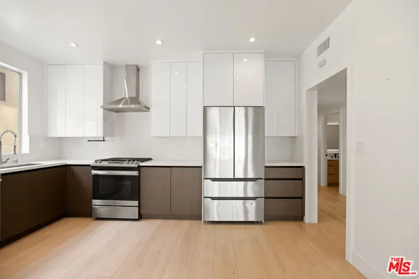 a kitchen with stainless steel appliances granite countertop a sink a stove and a refrigerator