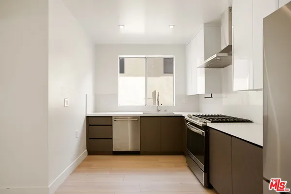 a view of an empty room with wooden floor and closet