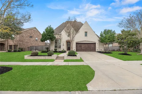 a front view of a house with a yard and potted plants