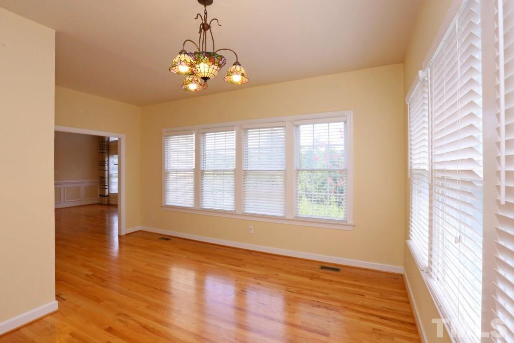 8204 Eden Close Court Raleigh, NC 27613 - Photo 11 of 25 a view of an empty room with wooden floor and a window