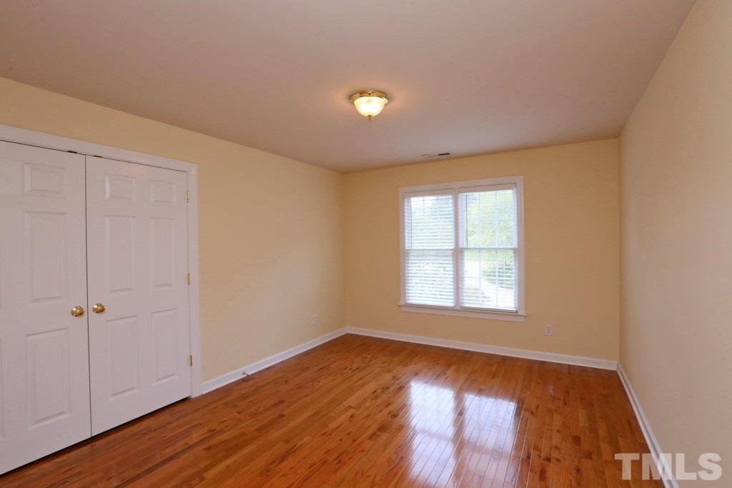 8204 Eden Close Court Raleigh, NC 27613 - Photo 18 of 25 an empty room with wooden floor and windows