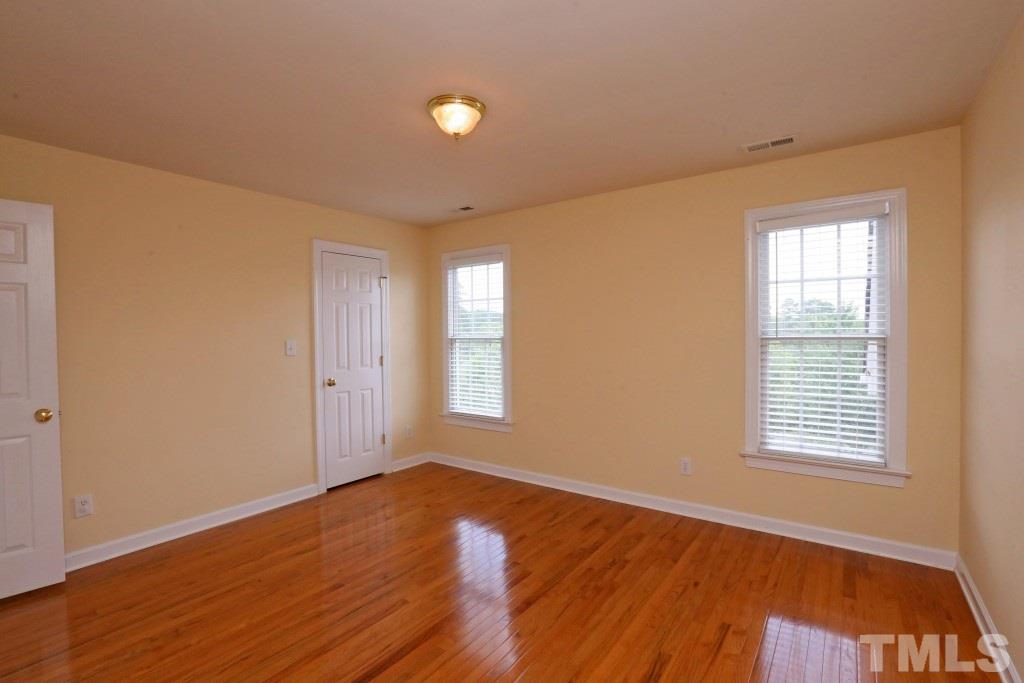 8204 Eden Close Court Raleigh, NC 27613 - Photo 19 of 25 an empty room with wooden floor and windows