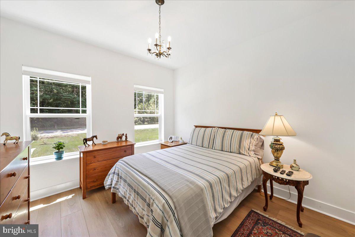 36755 Double Bridges Road Frankford, DE 19945 - Photo 21 of 38 a bed room with a bed and a chandelier