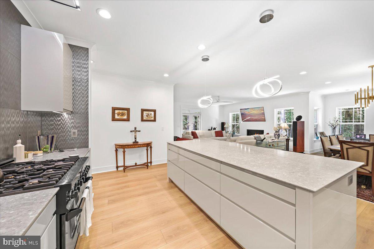 36755 Double Bridges Road Frankford, DE 19945 - Photo 5 of 38 a large kitchen with kitchen island a stove a sink a dining table and chairs with wooden floor