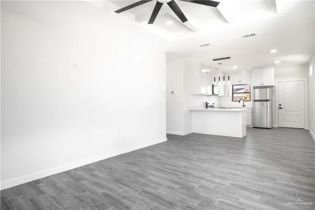 a view of a kitchen with a sink and wooden floor
